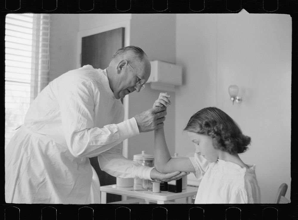 [Untitled photo, possibly related to: Doctor examines fractured arm, FSA (Farm Security Administration) camp clinic…