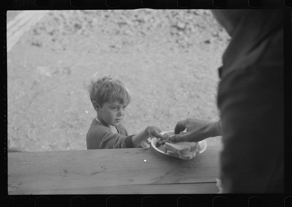 Small boy at mealtime in the camp for white flood refugees, Forrest City, Arkansas. Sourced from the Library of Congress.