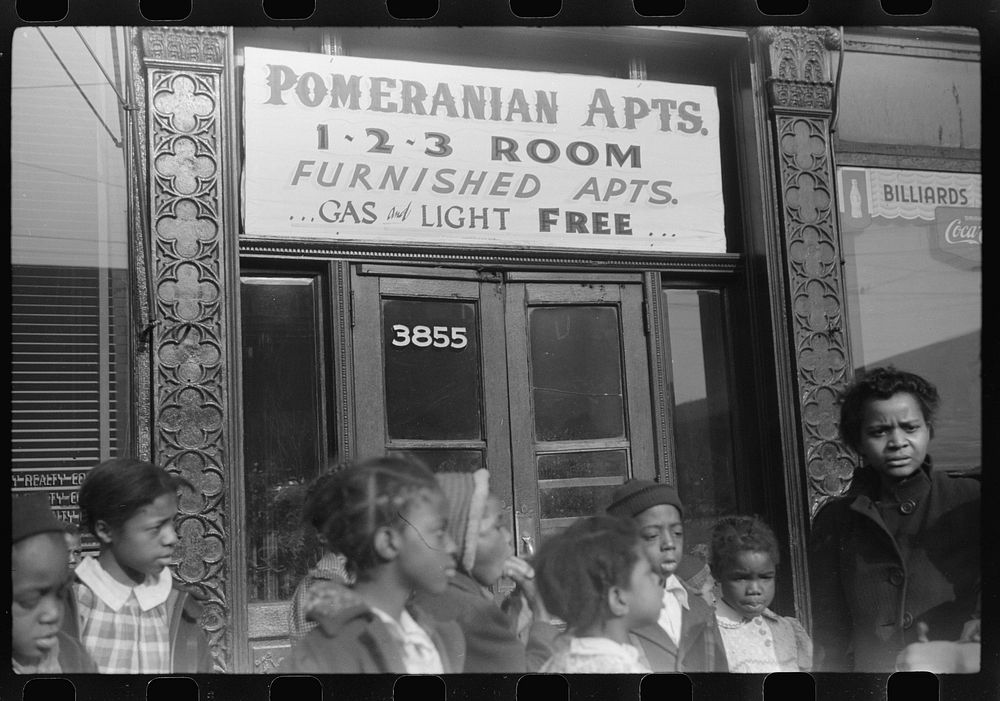 Children in front of "kitchenette" apartment, Black Belt, Chicago, Illinois. Sourced from the Library of Congress.