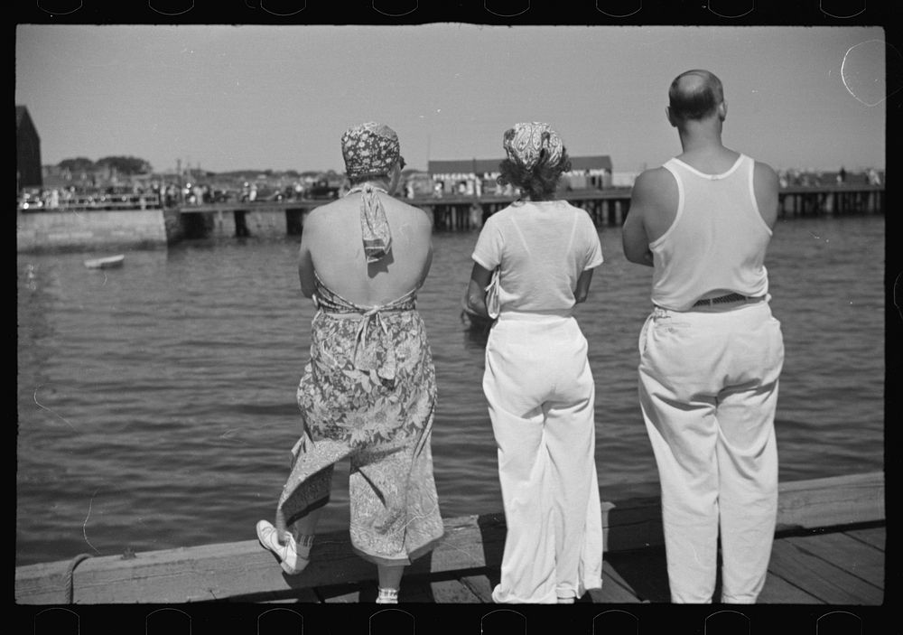 Summer residents watch the tourist boat arrive from Boston, Provincetown, Massachusetts. Sourced from the Library of…