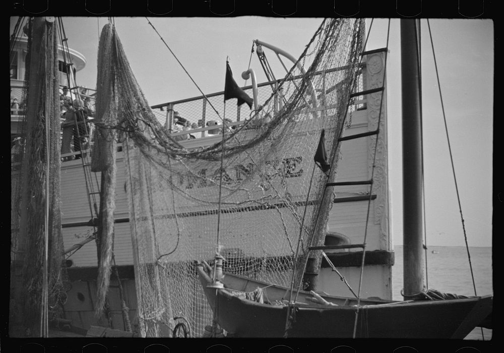 The economy of a town: fishing and the tourist trade. A fishing boat in front of the S.S. "Romance," a tourist boat which…