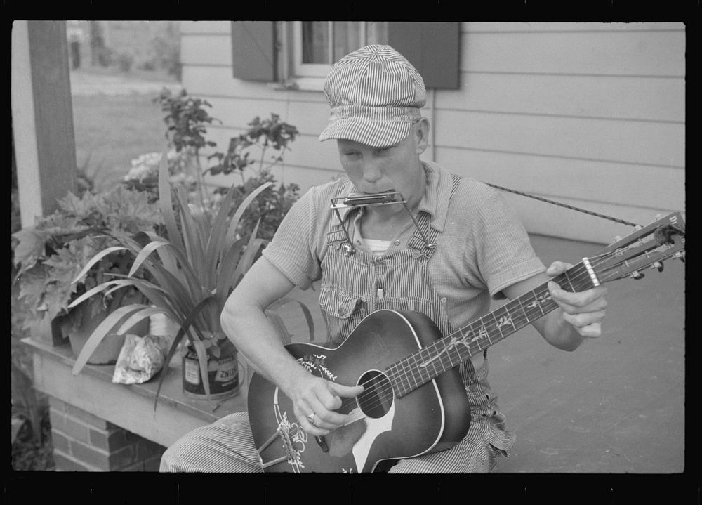 Westmoreland homesteader playing a mouth organ and a guitar, Pennsylvania. Sourced from the Library of Congress.