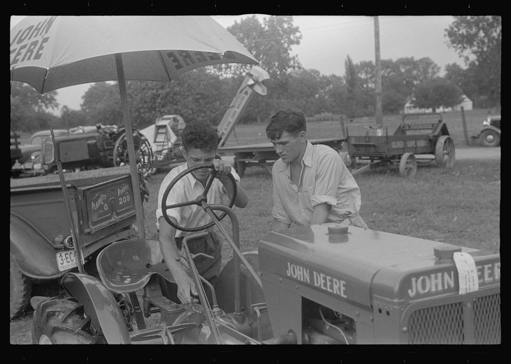 Examining tractor on display at county fair, central Ohio. Sourced from the Library of Congress.