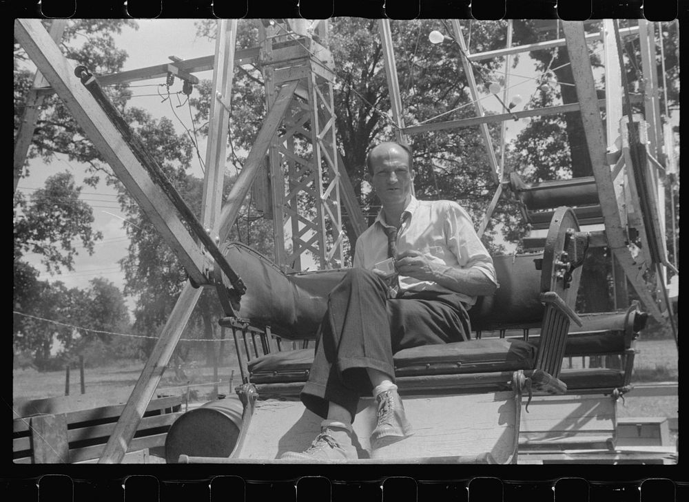 Operator of ferris wheel resting at county fair in central Ohio. Sourced from the Library of Congress.