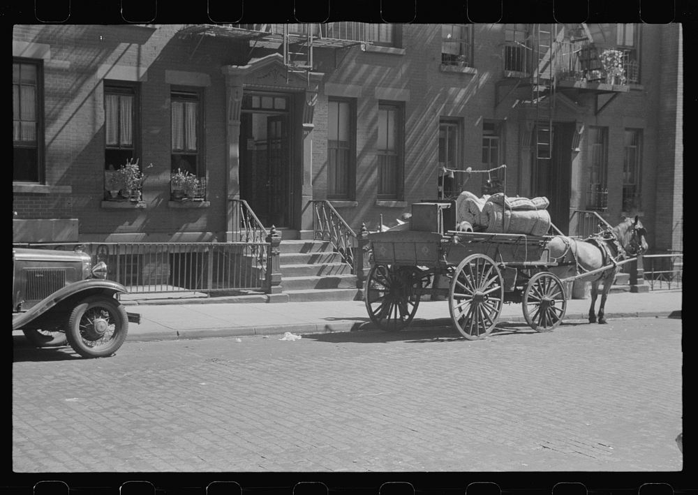New York, New York. 61st Street between 1st and 3rd Avenues. A tenant is moving on horse-drawn wagon. Sourced from the…