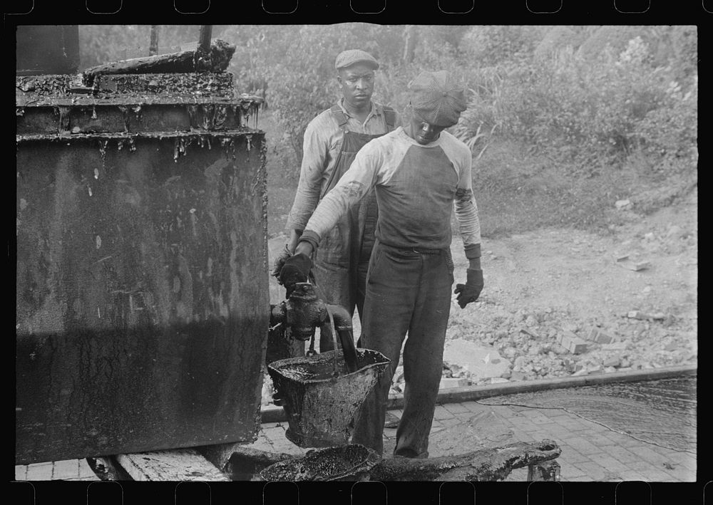 Workers repairing Route 40, central Ohio. Vat for heating tar used in repairing brick road on Route 40. Sourced from the…