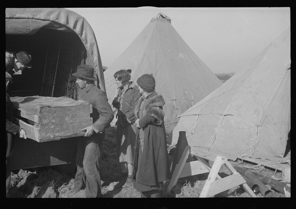 Unloading household goods of a family of white flood refugees in camp at Forrest City, Arkansas. Sourced from the Library of…