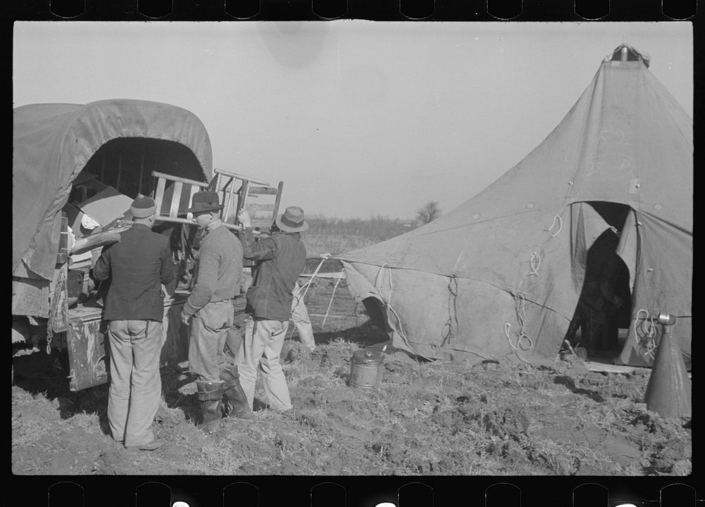 [Untitled photo, possibly related to: Unloading the household goods of a family who is being moved into the camp for white…