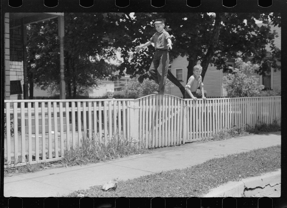 [Untitled photo, possibly related to: Boys walking fence. Washington, Indiana]. Sourced from the Library of Congress.