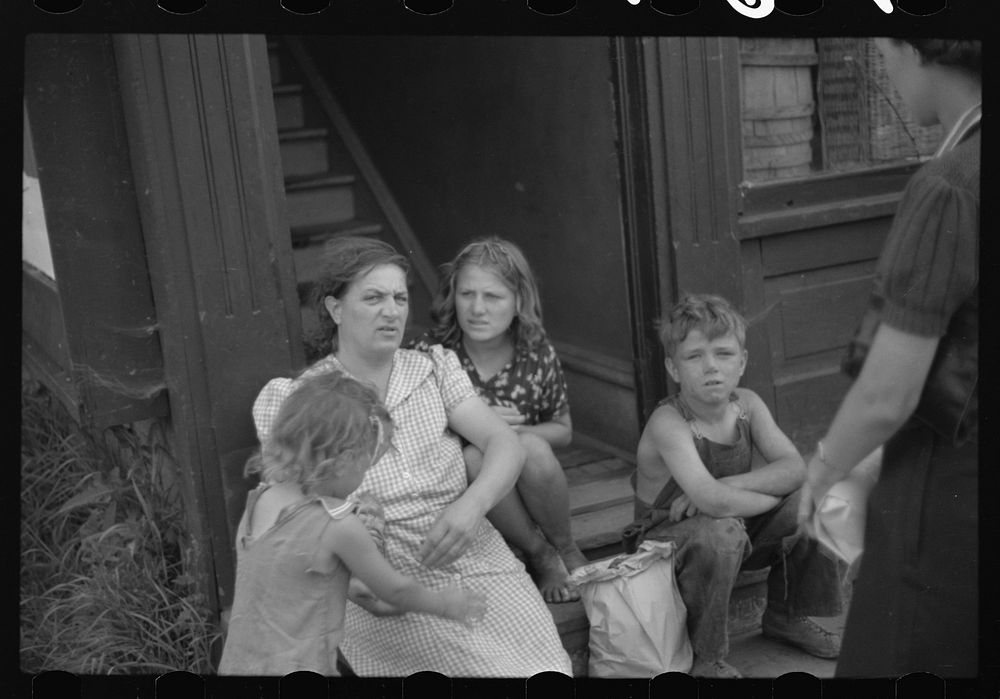 People sitting on steps in front of apartment. Superior, Wisconsin. Sourced from the Library of Congress.