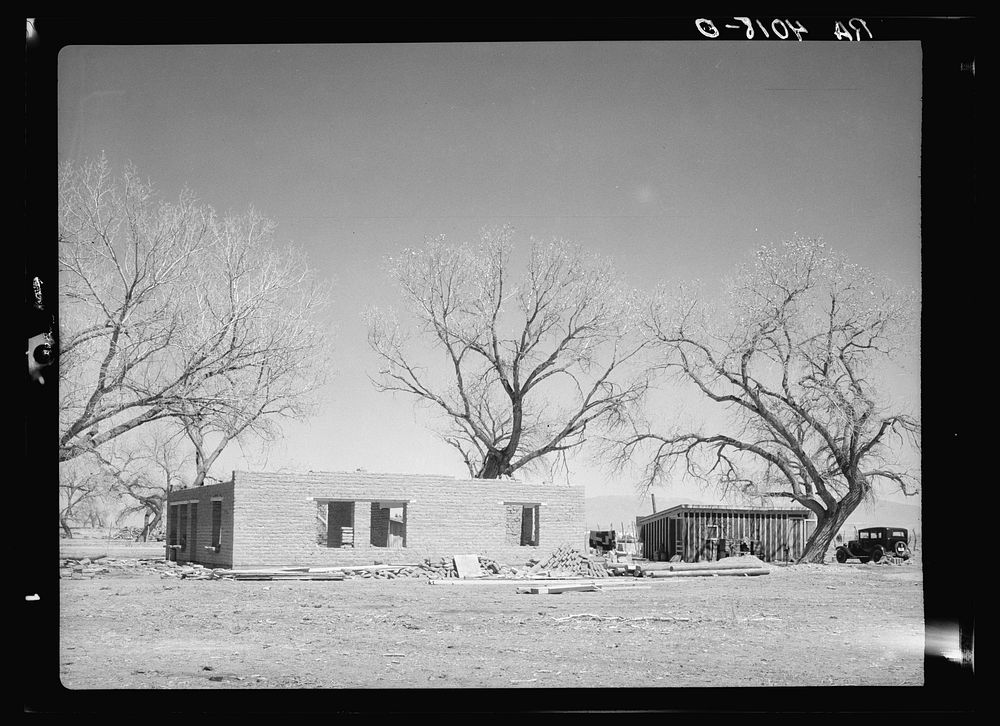 New adobe house. Temporary house in background. Bosque Farms, New Mexico. Sourced from the Library of Congress.