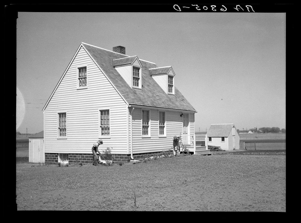 Granger homesteader and son working in flower bed. Iowa. Sourced from the Library of Congress.