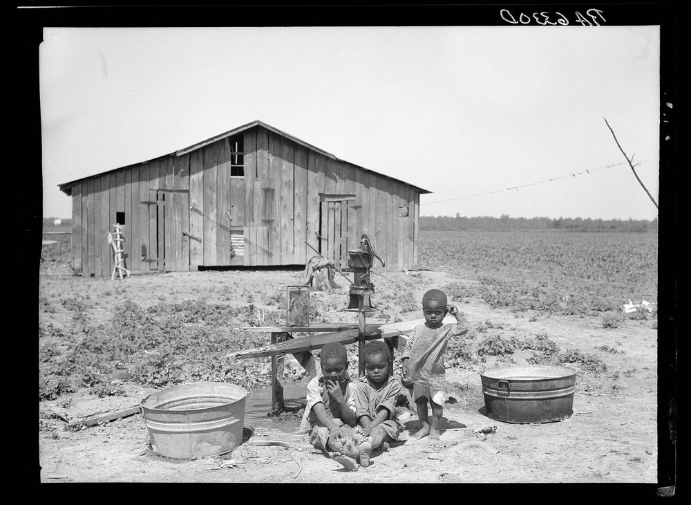 Children of  sharecropper at pump. Near West Memphis, Arkansas. Sourced from the Library of Congress.