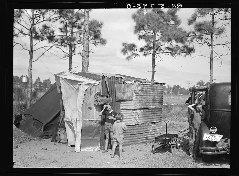 The temporary home of a migrant citrus worker and his family. Now camped near the packing plant of Winterhaven, Florida. The…