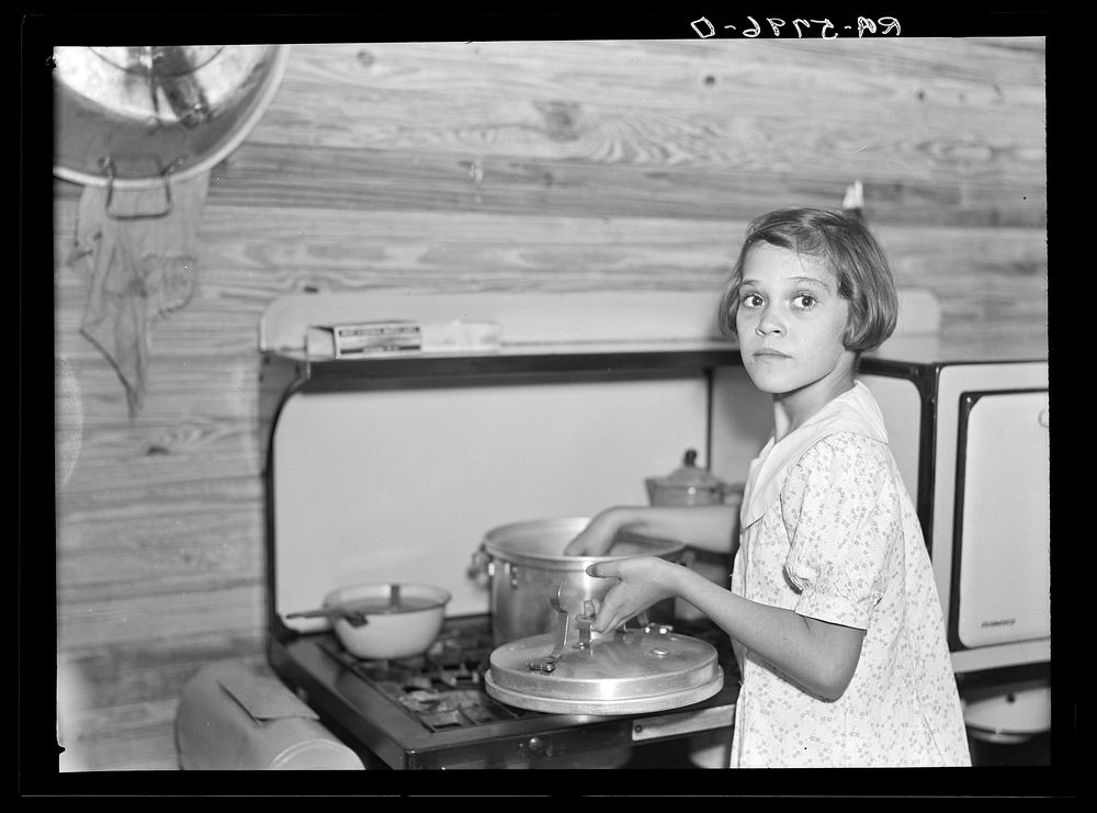 While father and mother are both at work in the citrus packing plant this little girl keeps house. Winterhaven, Florida.…