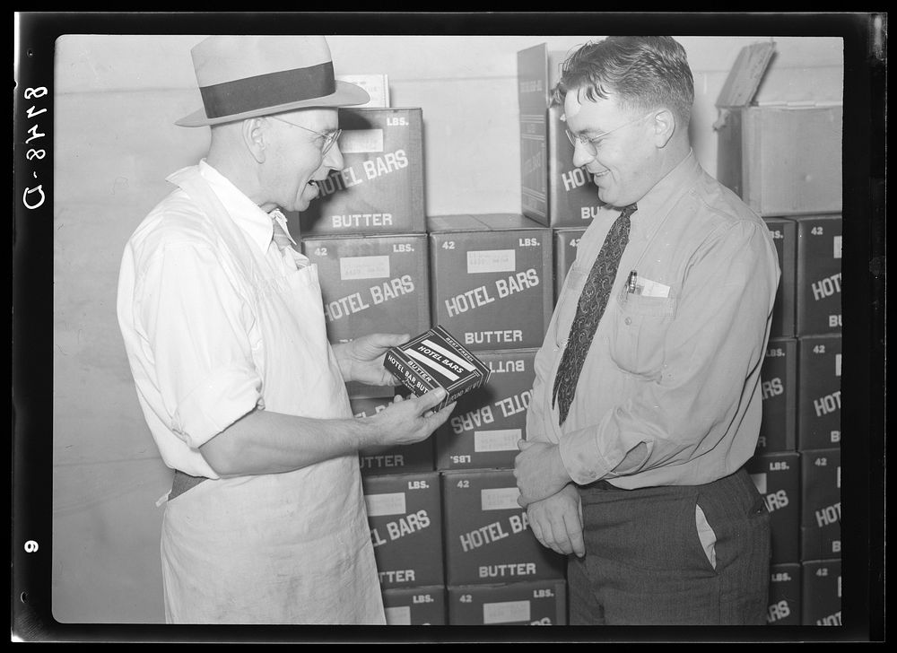 Manager of co-op creamery talking with Farm Security Administration county supervisor. Baldwin City, Kansas. Sourced from…