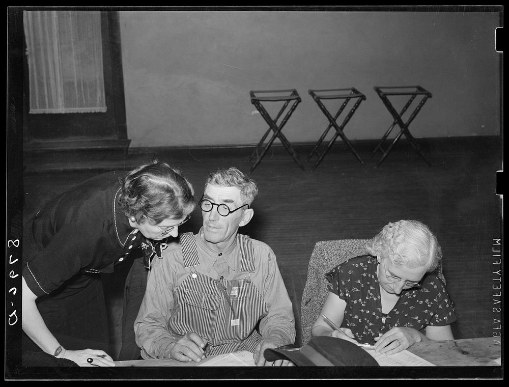 Home supervisor helping farm couple at group meeting. York, Nebraska. Sourced from the Library of Congress.