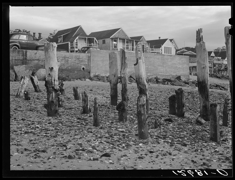 Ruins of fish pier with breakwater and new tourist cottages in the background. Provincetown, Massachusetts. Sourced from the…