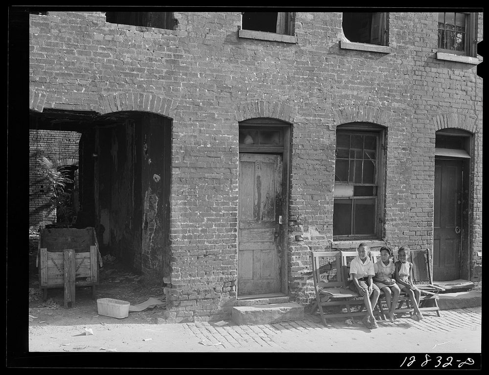 Alley dwelling section. The house in front of which the children are sitting is inhabited; the one to the right is gutted.…