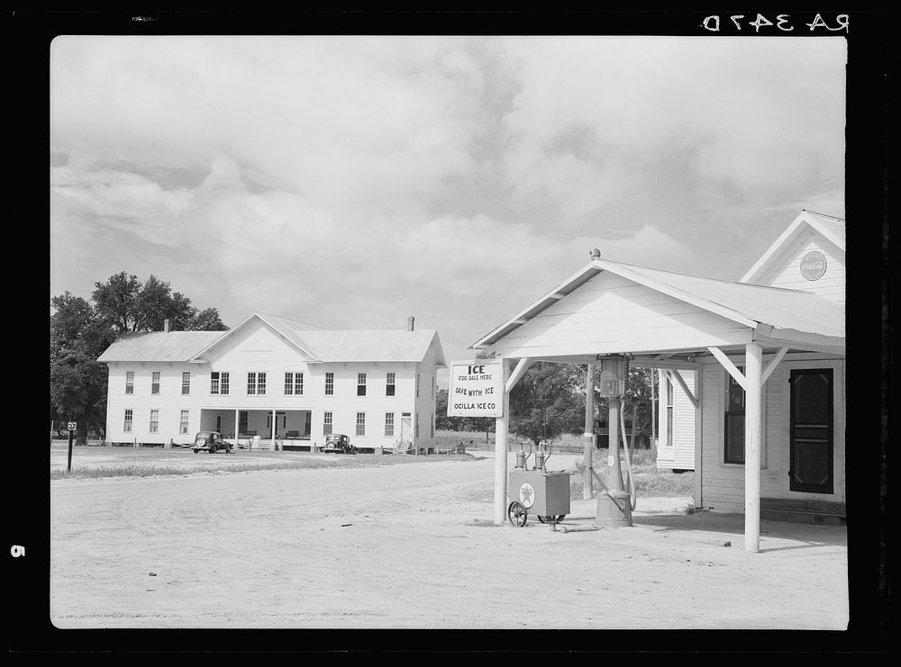 [Untitled photo, possibly related to: Grocery and filling station with former courthouse in background in Irwin County…