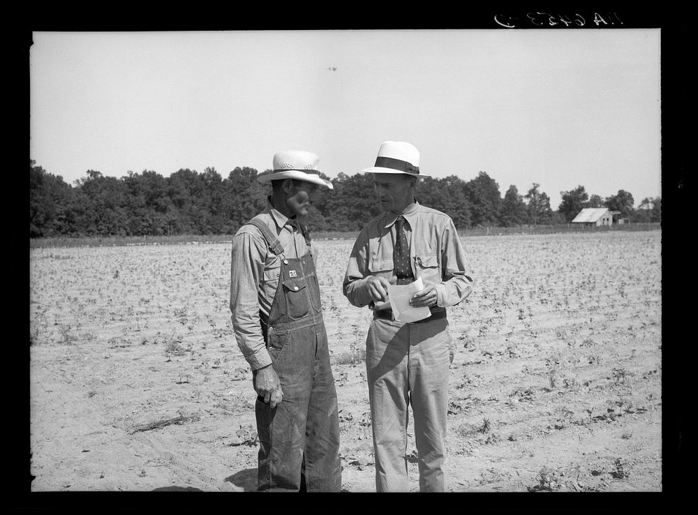 [Untitled photo, possibly related to: Resettlement Administration rehabilitation loan supervisor talking with client on…