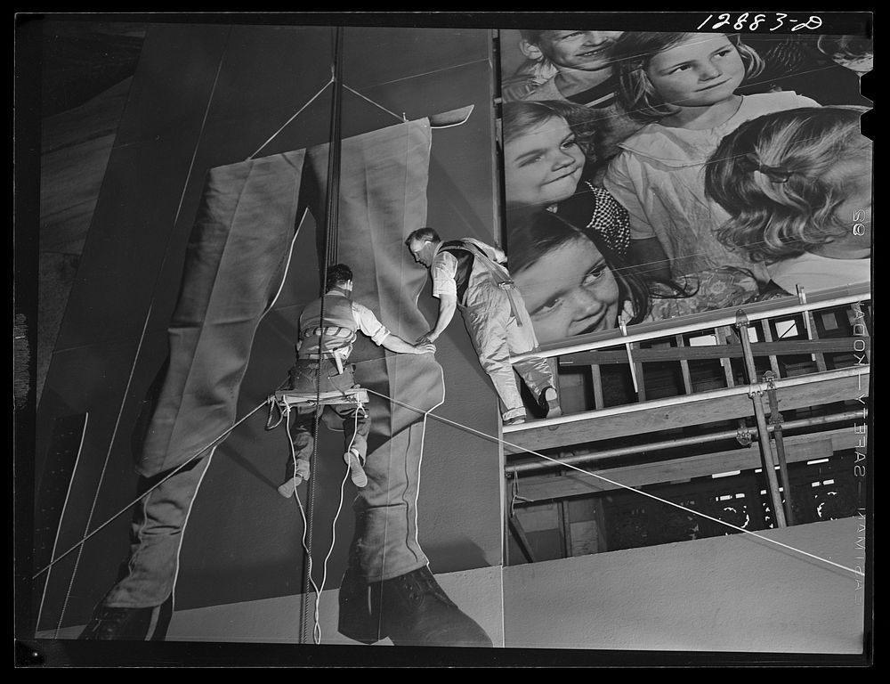 New York, New York. Installing the defense bond sales photomural, prepared by the Farm Security Administration, in the…