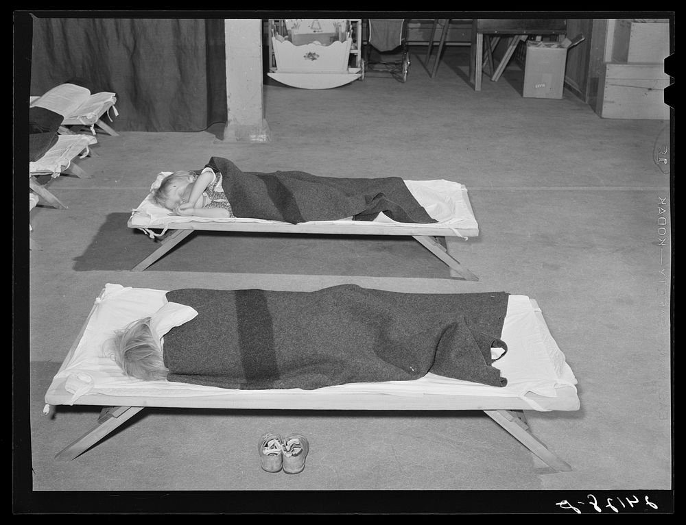 Children sleep in nursery while mothers work. Shafter migrant camp.  Shafter, California. Sourced from the Library of…