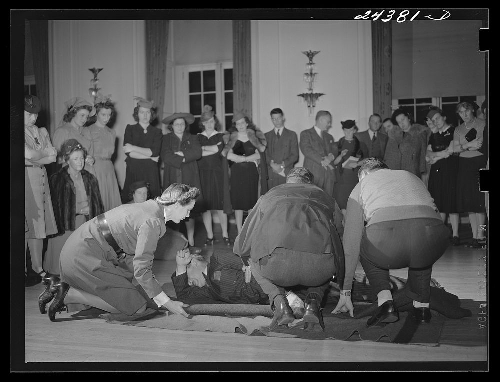 [Untitled photo, possibly related to: Civilian defense volunteers receiving instruction in proper care for man with spine…