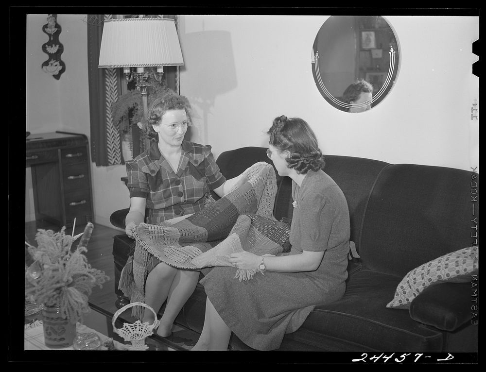 Mrs. Hardeman showing hand-woven curtains to Mrs. Golden, who also works at weaving shop. Dailey, West Virginia. Sourced…