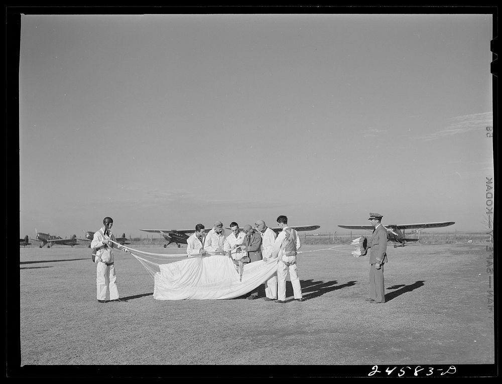 [Untitled photo, possibly related to: Instructor explaining operation of parachute to student pilots. Meacham Field, Fort…