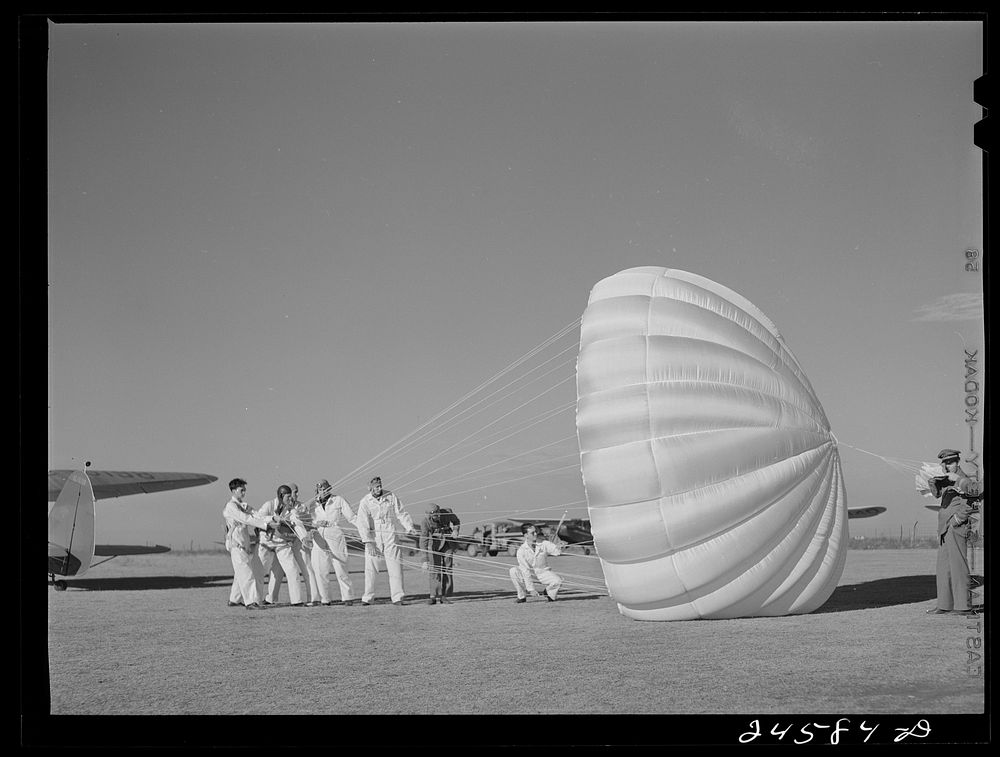 Instructor explaining operation of parachute to students. Meacham Field, Fort Worth, Texas. Sourced from the Library of…