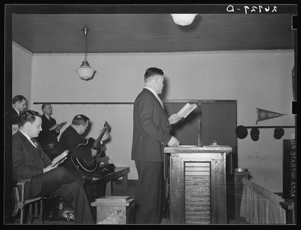 Preacher conducting hymn singing. Pentecostal church, Cambria, Illinois. Sourced from the Library of Congress.