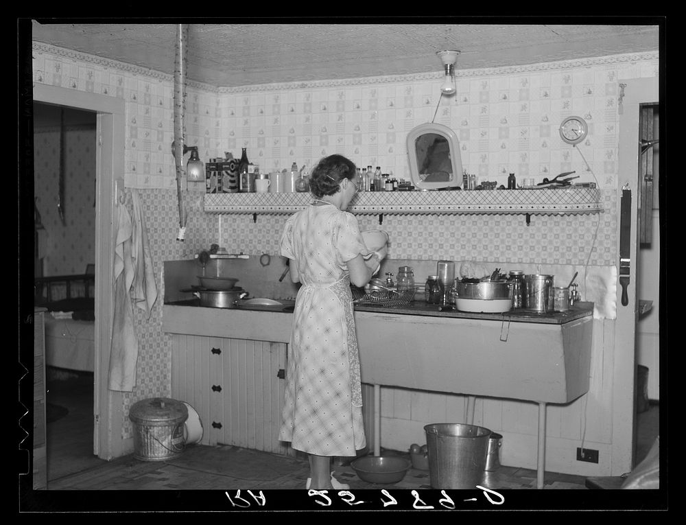 Hired girl washing dishes on the McNally farm. Kirby, Vermont. Sourced from the Library of Congress.