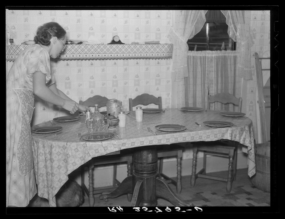 Hired girl setting the table. McNally farm, Kirby, Vermont. Sourced from the Library of Congress.