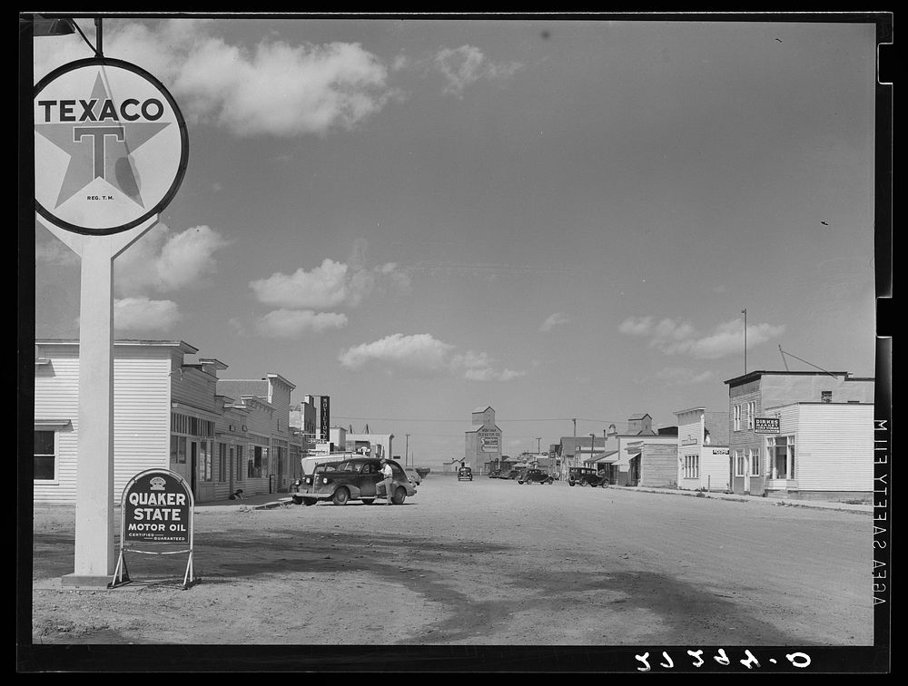 Main street of small agricultural community having population of 700 in center of wheat raising area. Fairfield, Montana.…