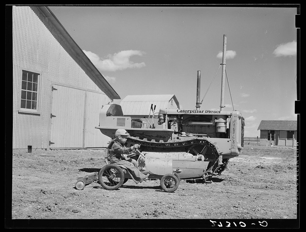 [Untitled photo, possibly related to: Wheat farmer's son playing with tractor. Cascade County, Montana]. Sourced from the…