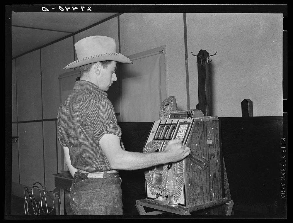 Dude playing a slot machine. Birney, Montana. Sourced from the Library of Congress.
