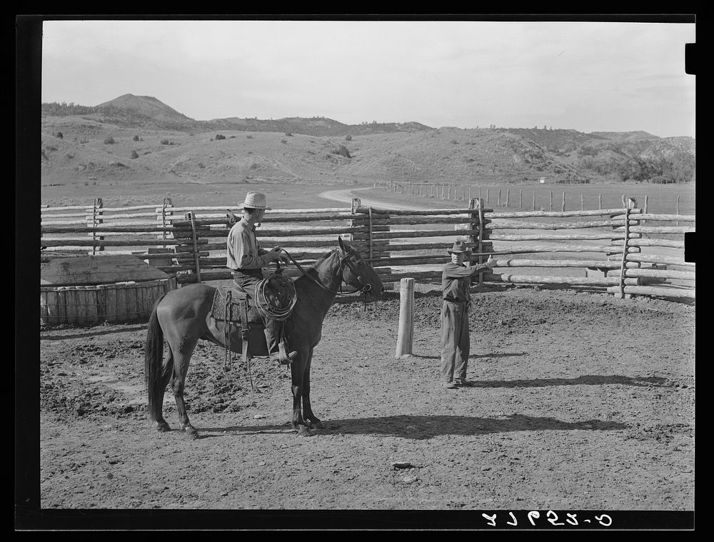 Giving directions to visiting cowhand. Quarter Circle 'U' Ranch, Montana. Sourced from the Library of Congress.