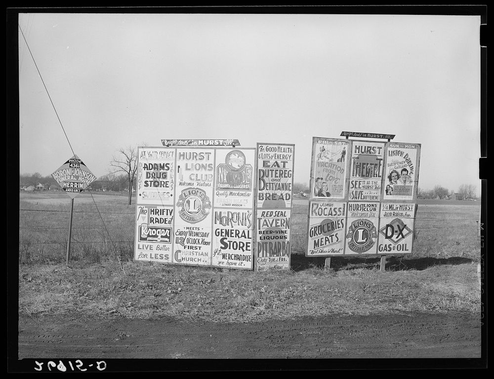 Signs along highway approaching Hurst, Illinois. Williamson County, Illinois. Sourced from the Library of Congress.