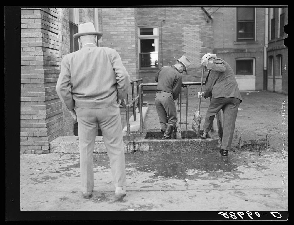 Men cleaning their boots after visit to stockyards. Denver, Colorado. Sourced from the Library of Congress.