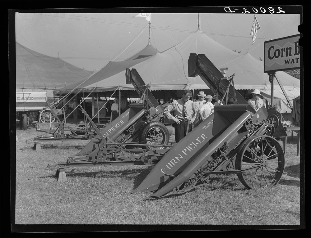Farmers examine new corn picker at Iowa State Fair. Des Moines, Iowa. Sourced from the Library of Congress.