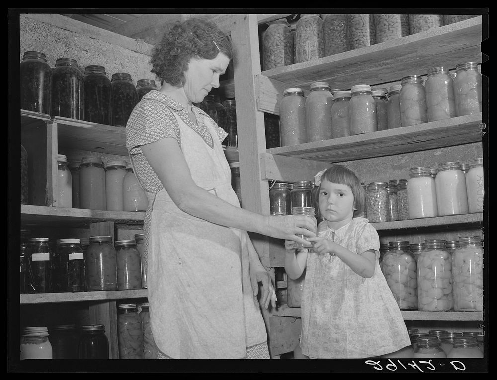 [Untitled photo, possibly related to: Mrs. Lawrence Corda, wife of tiff miner, with some of her 800 quarts of food canned…