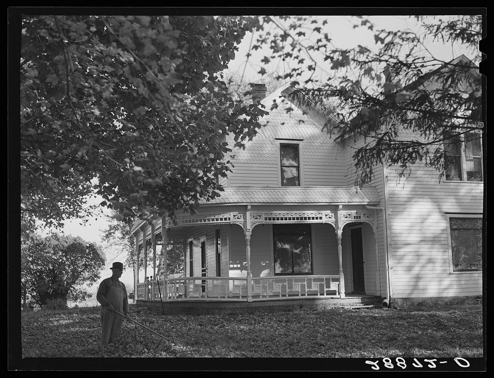 [Untitled photo, possibly related to: Farmer raking leaves on lawn of his home. Grundy County, Iowa]. Sourced from the…