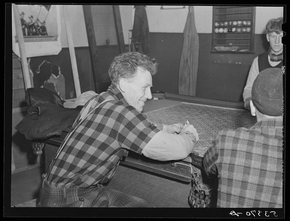 Farmers and townspeople playing cards in pool room on winter morning. Woodstock, Vermont. Sourced from the Library of…
