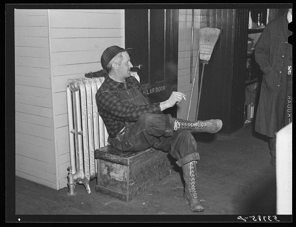 Railroad worker waiting in baggage room for train arrival. Railway station, Mount Whittier, New Hampshire. Sourced from the…