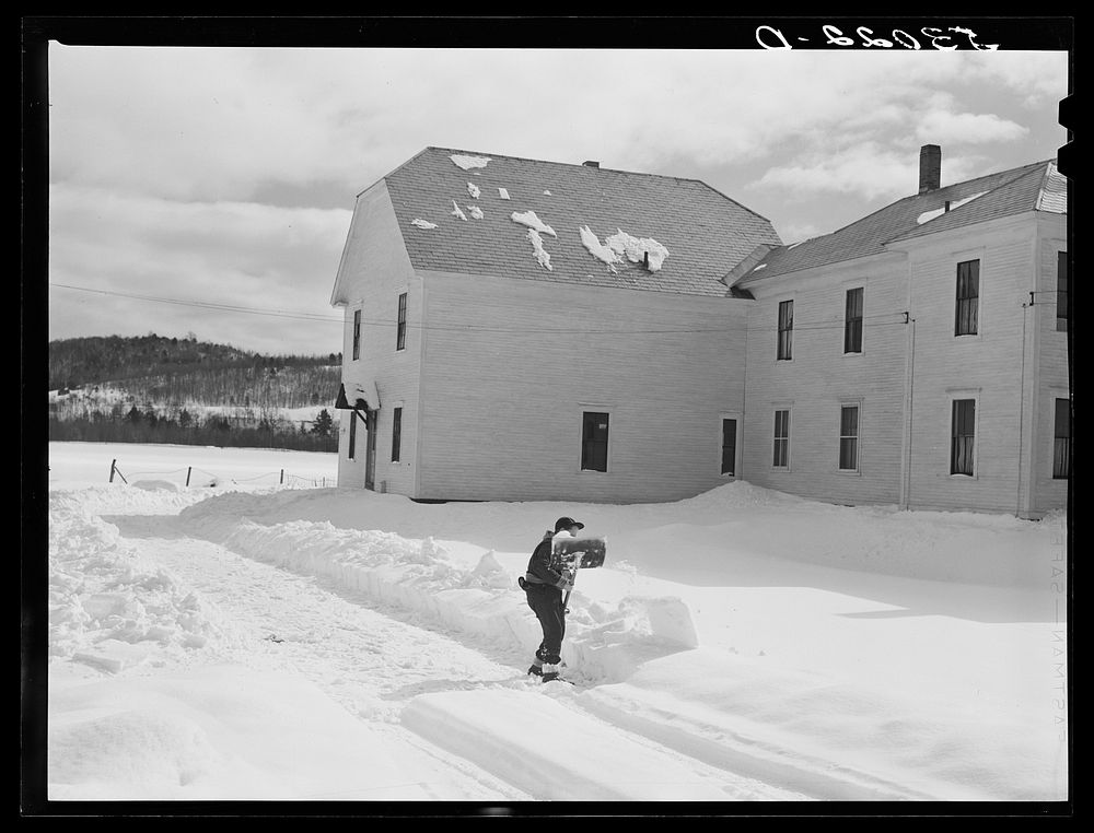 Farmer's son shoveling snow out of driveway near Putney, Vermont. Sourced from the Library of Congress.