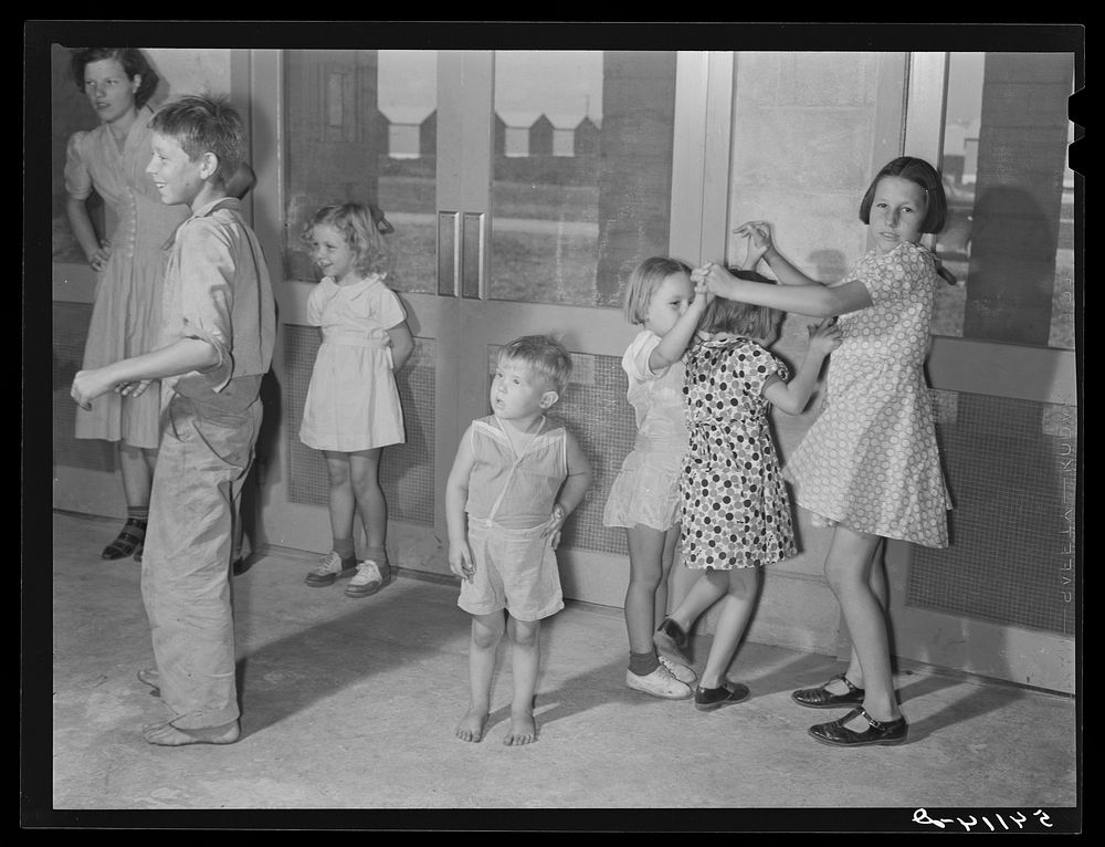 Supervised play hour for younger children in assembly building at Osceola migratory labor camp. Belle Glade, Florida.…