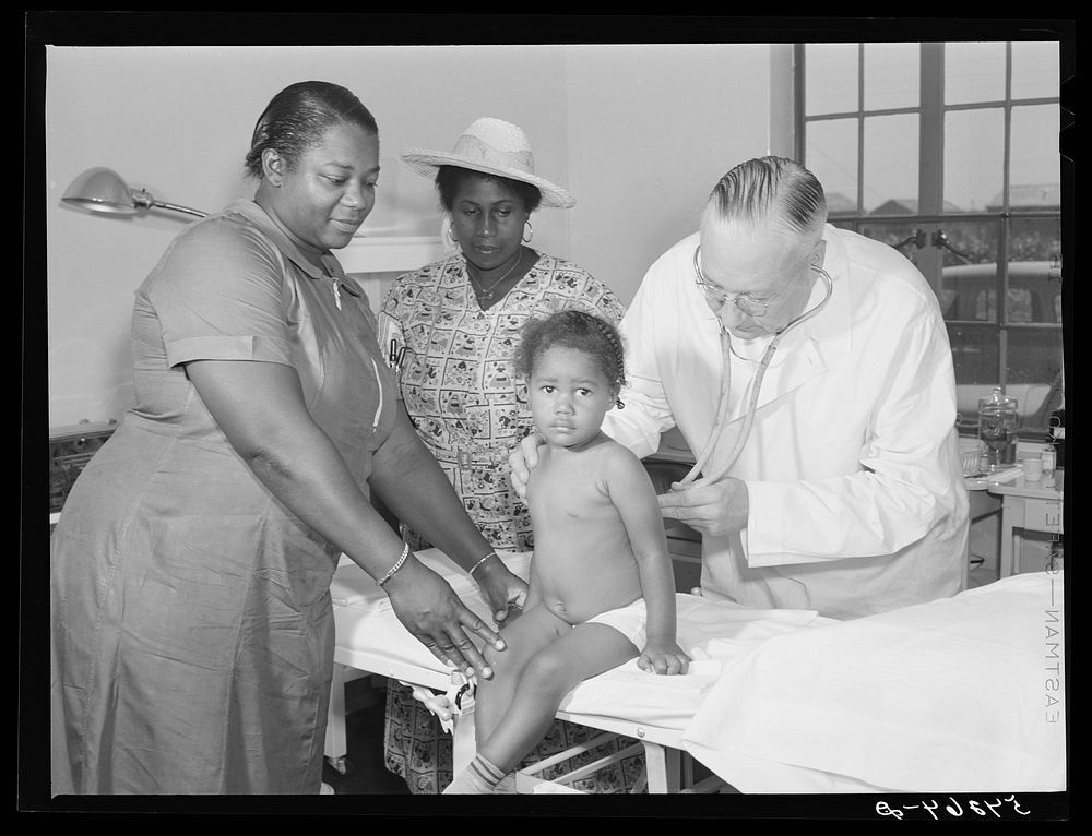 Doctor William J. Buck examining child, with mother and camp nurse assisting, in clinic at Okeechobee migratory labor camp.…