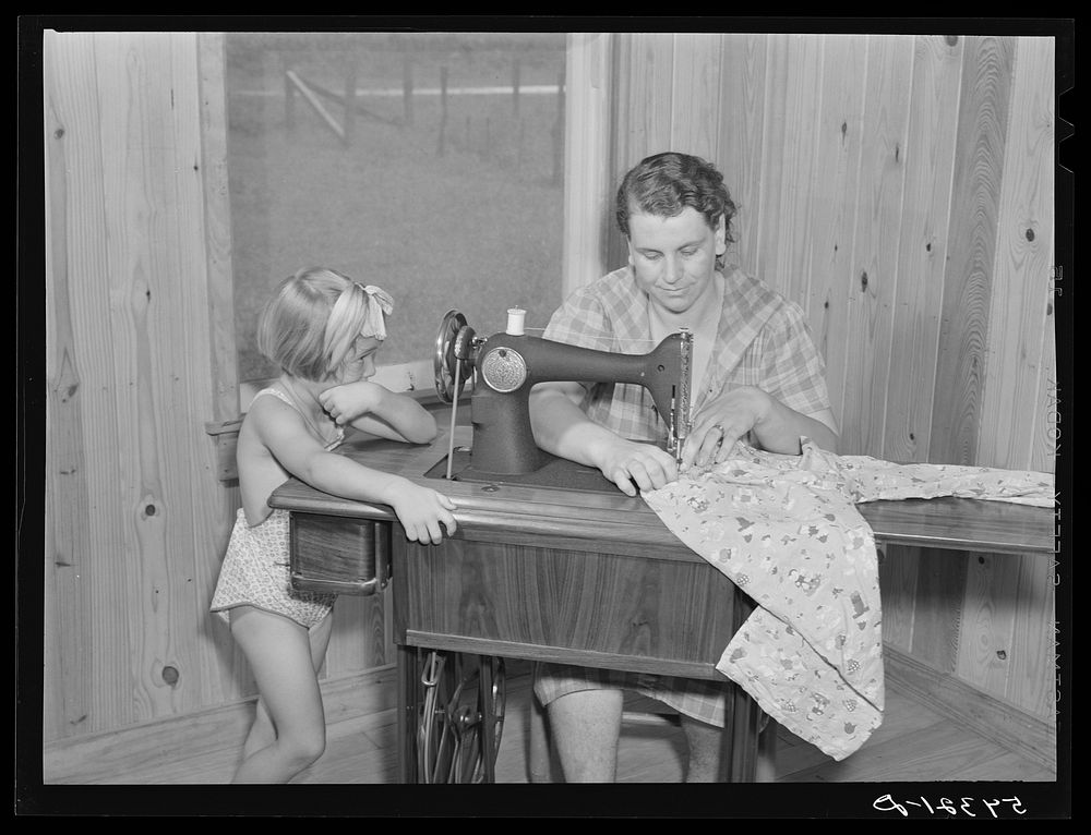 One of the project women making clothes for her family on her new sewing machine. Terrebonne Project, Schriever, Louisiana.…