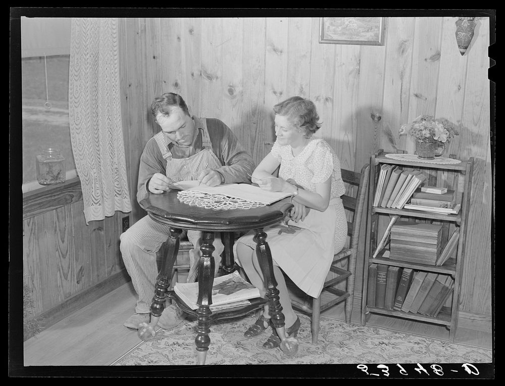 Mr. and Mrs. Verden Lee working on farm family record book in the living room of their home. Transylvania Project…